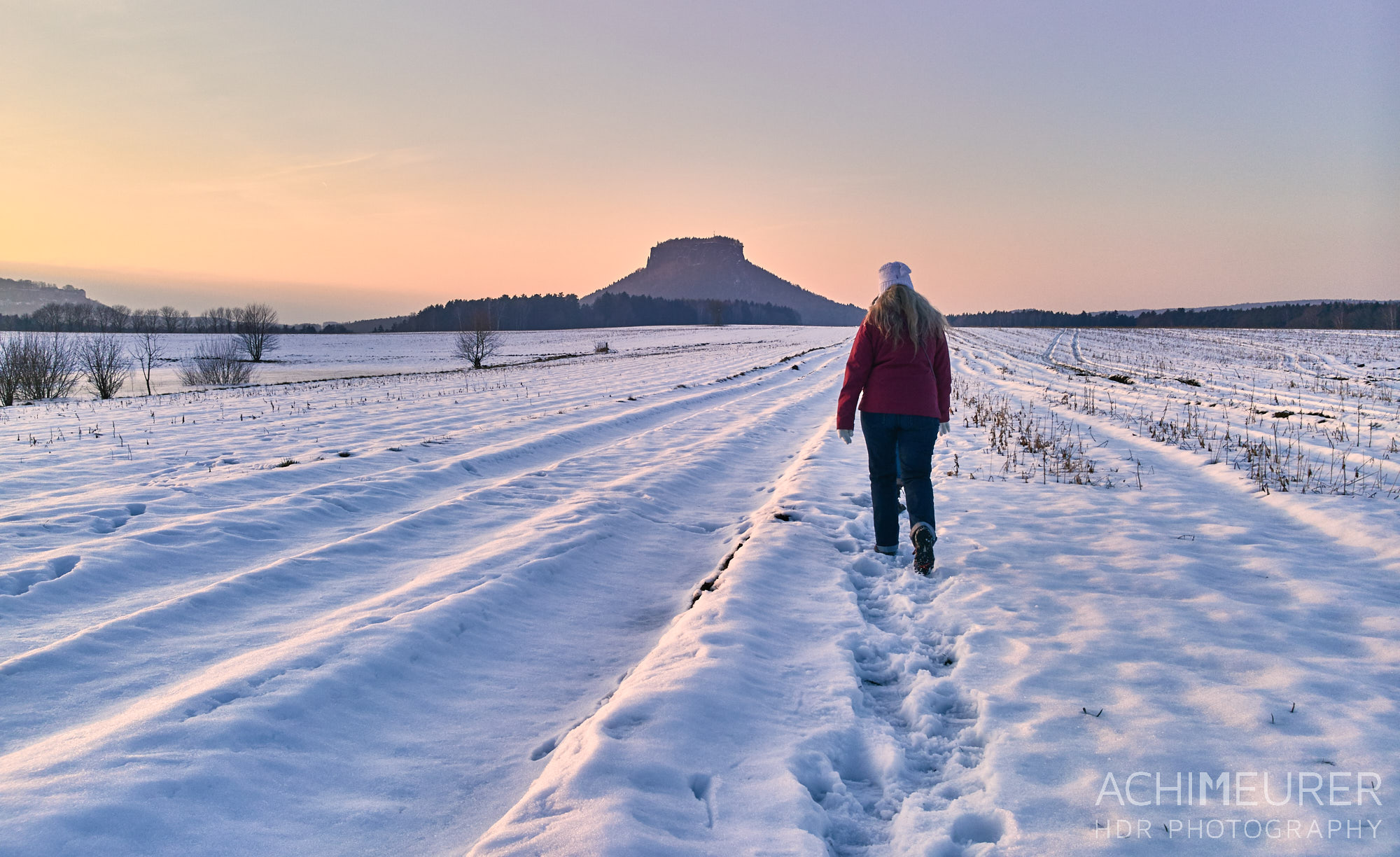Sonntagsspaziergang durch den Schnee bei Sonnenuntergang mit Blick auf den Lilienstein by Achim Meurer. 