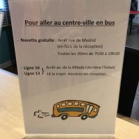 Aufsteller an einer Rezeption beschreibt Busverbindungen in die Stadt in französischer Sprache