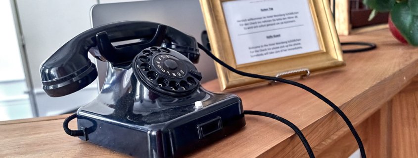 Altes Telefon mit Wählscheibe an der Rezeption